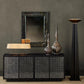 Modern interior with a sideboard, mirror, and decorative vases against a gray wall.