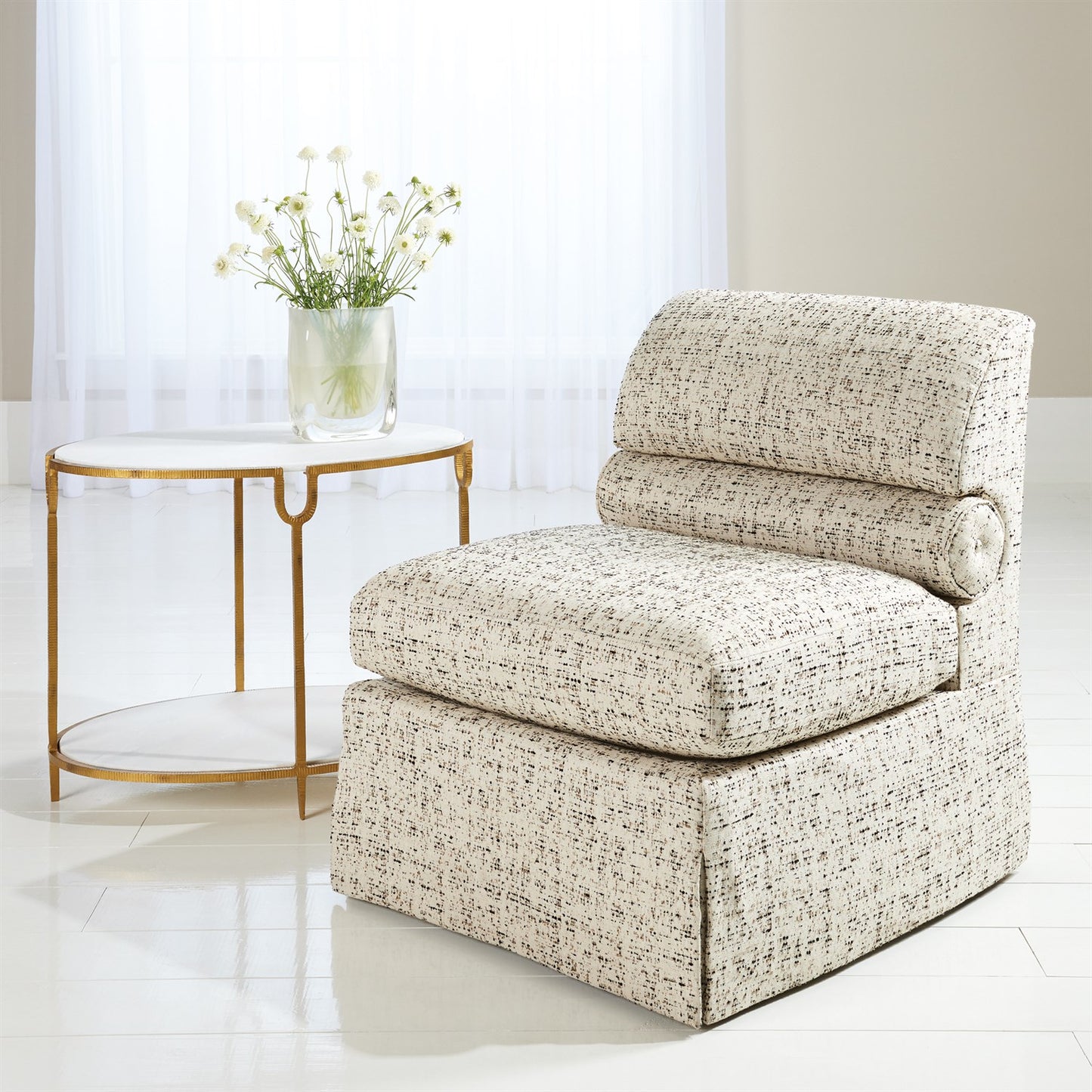Beige armchair in a room with a small round table and plant
