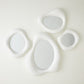 Modern wall mirror lwith four circular lights on a white background