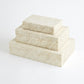 Set of three cream-colored decorative boxes with geometric patterns on a white background