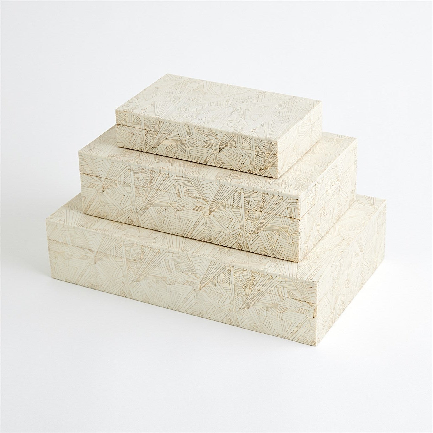 Set of three cream-colored decorative boxes with geometric patterns on a white background