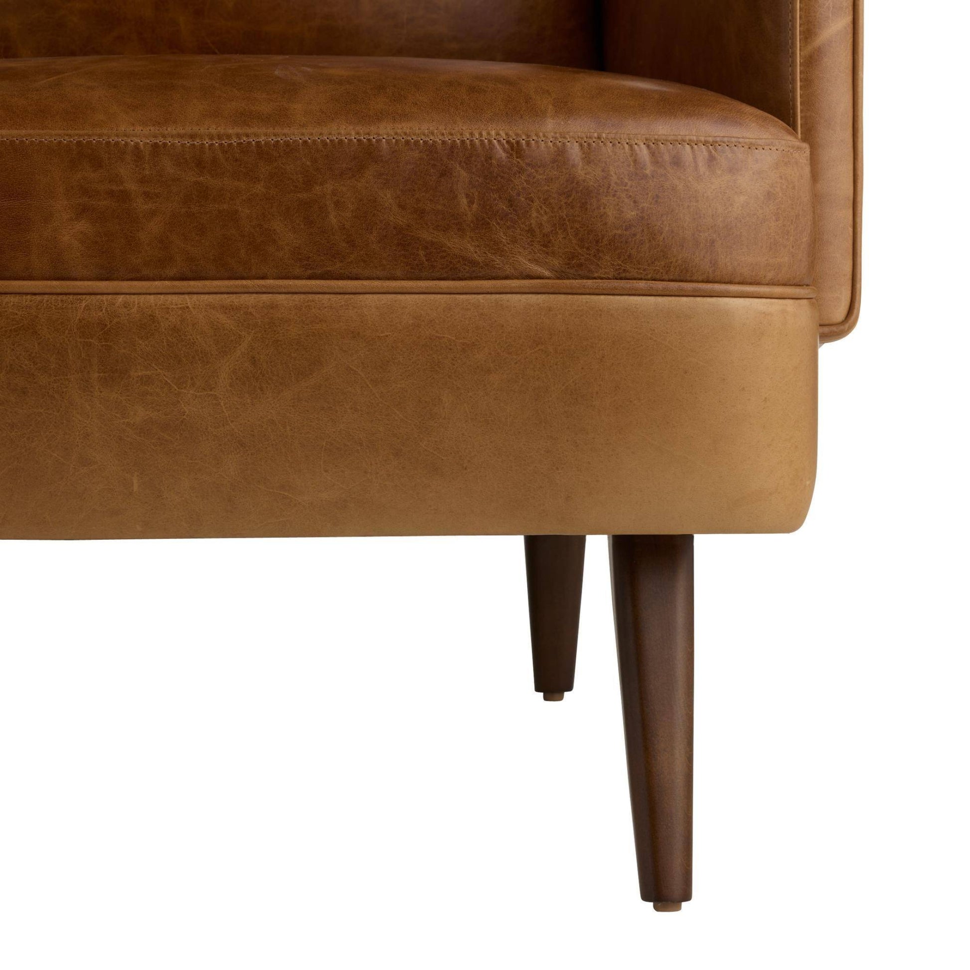 Close-up of a brown leather armchair with wooden legs on a white background