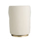 Beige cylindrical lamp with brass base on a white background
