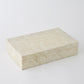 Rectangular beige box with a textured pattern on a white background