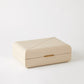 Beige jewelry box with a gold clasp on a white background