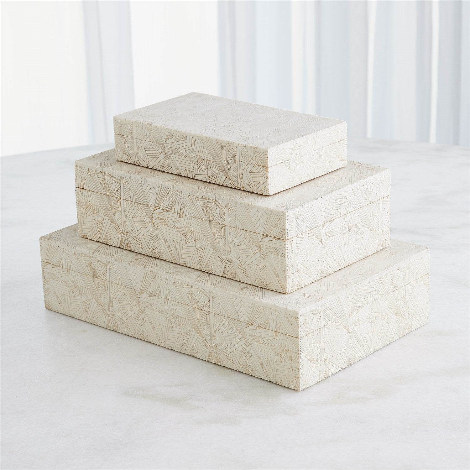 Three stacked decorative boxes with a geometric pattern on a white background