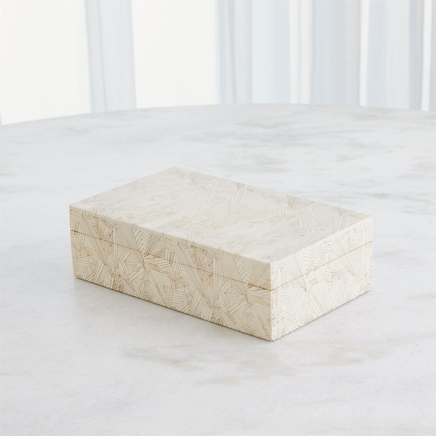 Rectangular marble box on a white surface with a blurred white background