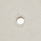 A close-up of a light beige textured surface with a circular hole in the center.
