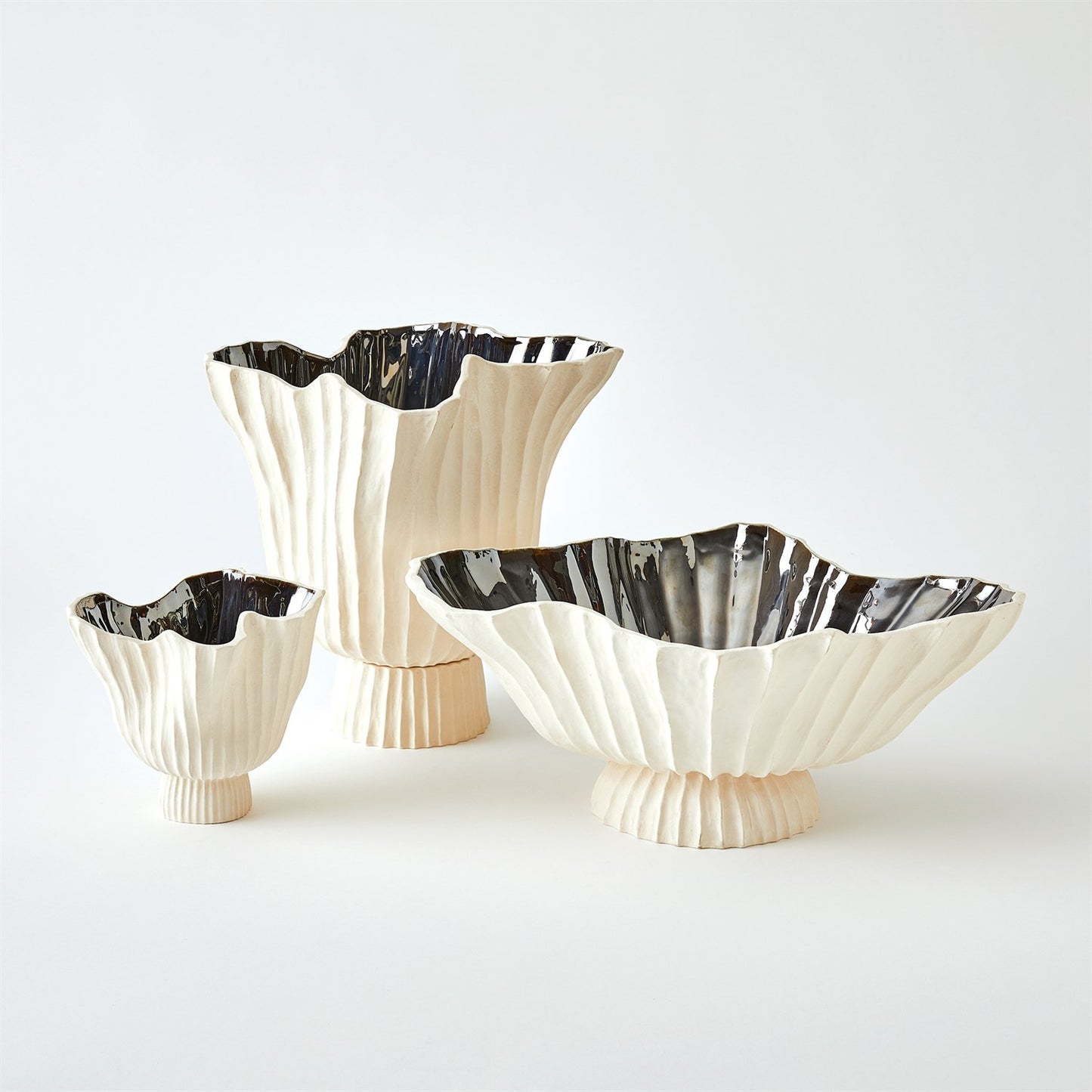 Three decorative bowls with fluted design and metallic rim on a white background