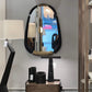 Round mirror with black frame on a stand in a room setting