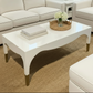 White coffee table with decorative items in a living room setting