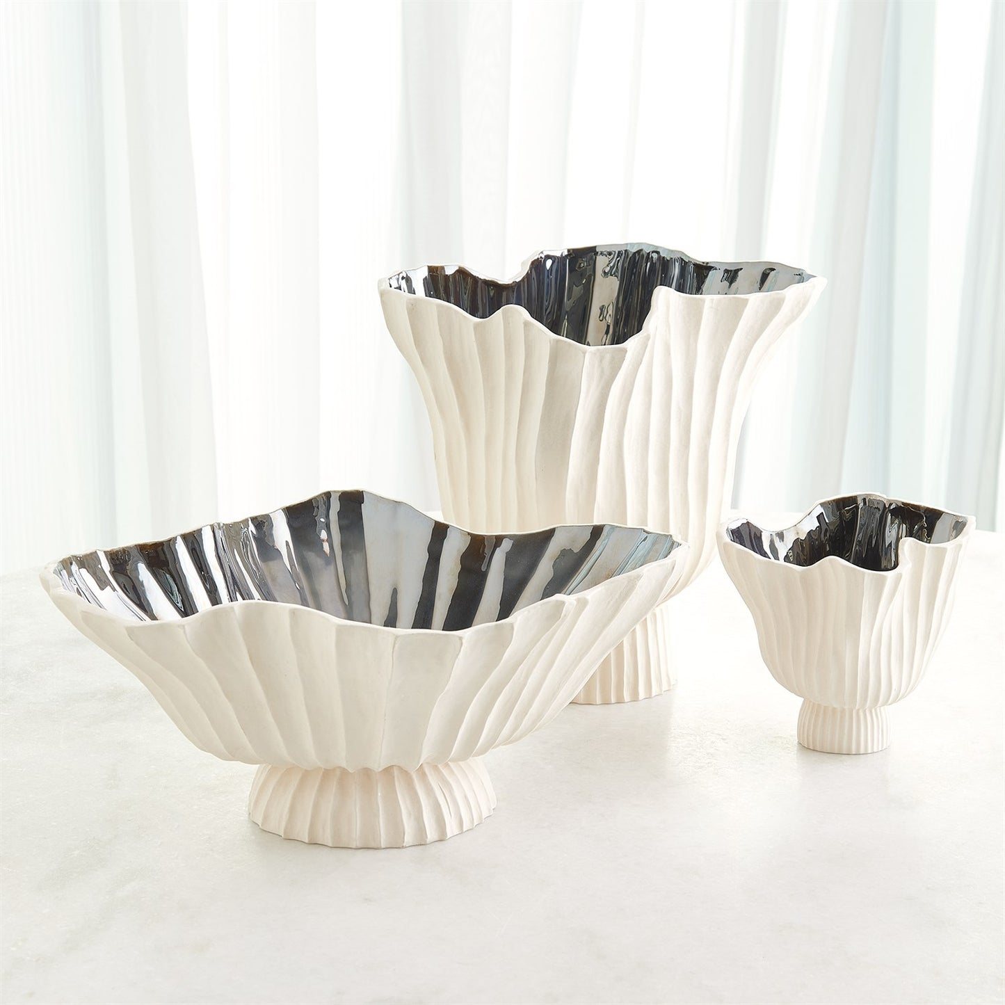 Set of three decorative bowls with scalloped edges on a white background