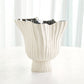 White decorative vase with ribbed texture on a white background