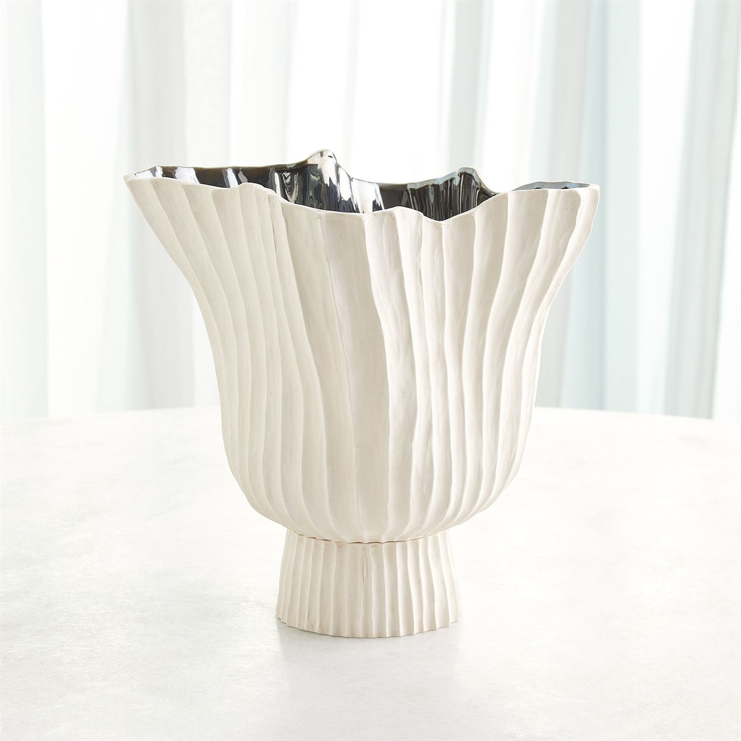 White decorative vase with ribbed texture on a white background