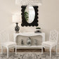 Decorative console table with mirror, chairs, and decorative items in a room.