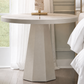 Round marble table with a lamp in a room with large windows and white curtains.
