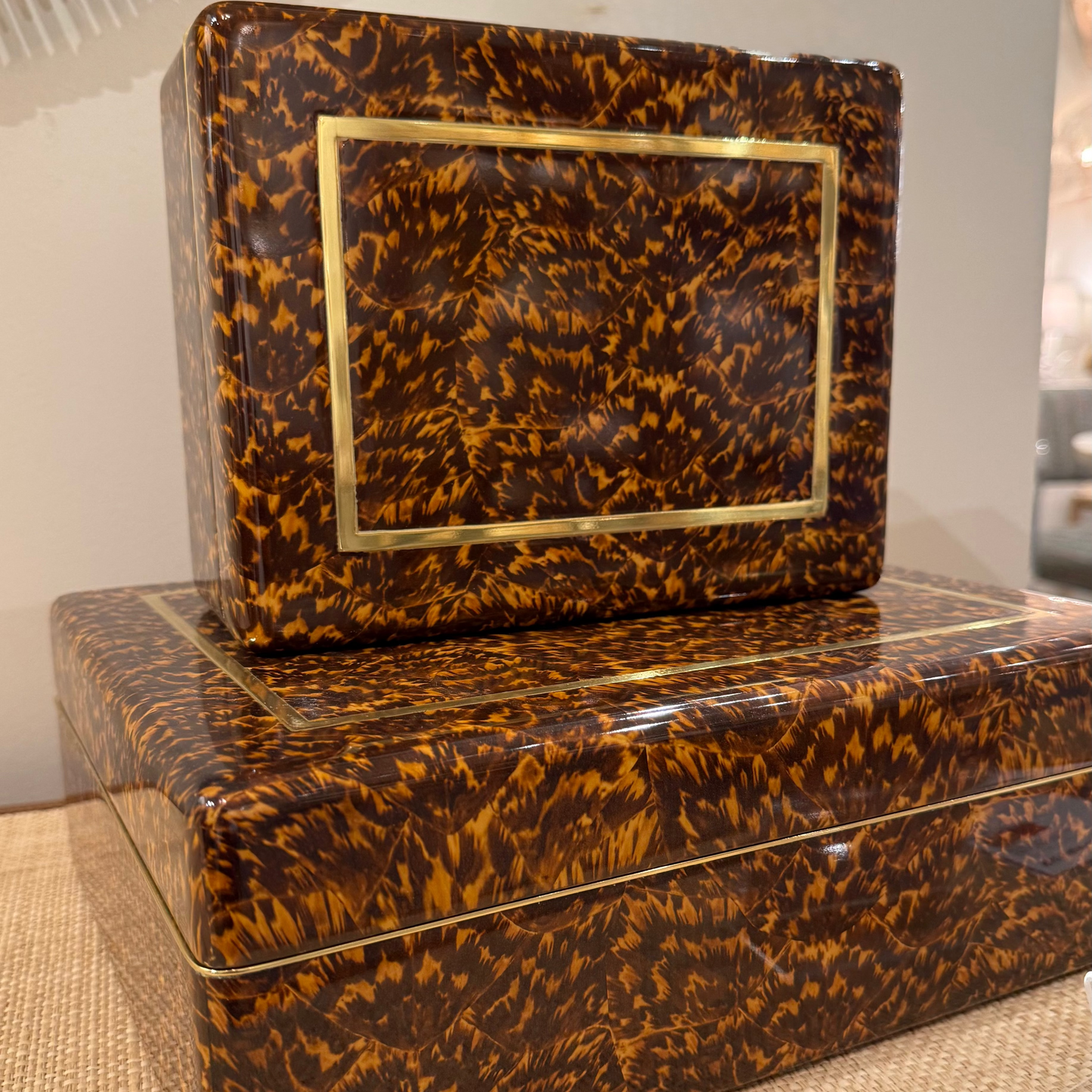 Tortoiseshell-patterned boxes with gold accents on a textured surface.