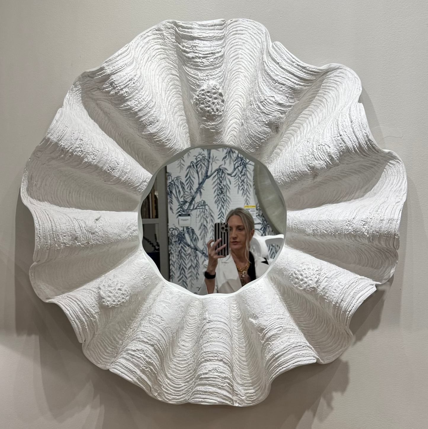 White textured wall mirror on a plain background