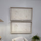 Beige armchair with cushions in a room with framed artwork on the wall.