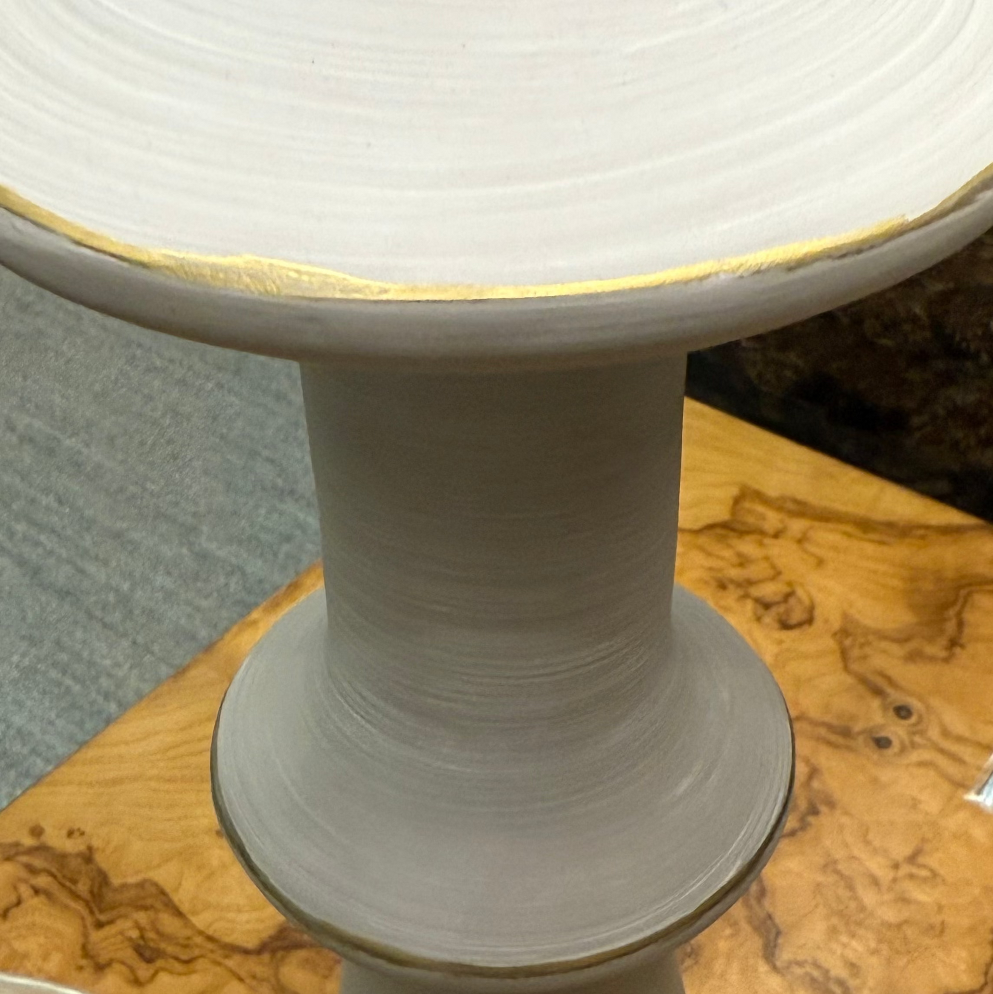 White ceramic lamp on a wooden surface with a blurred background