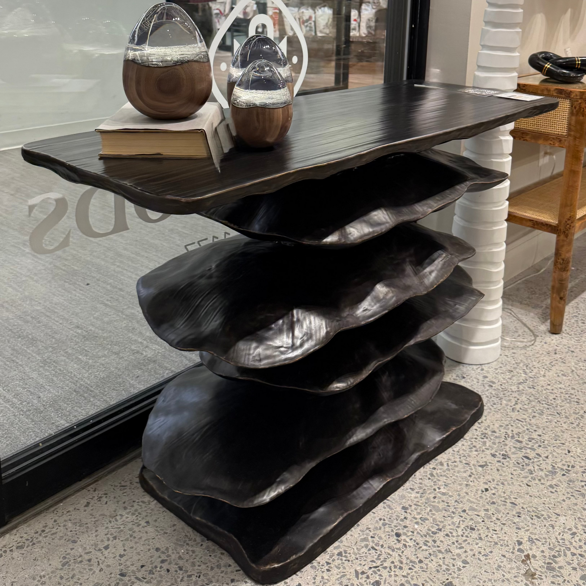 Dark wooden console table with decorative items in a store setting