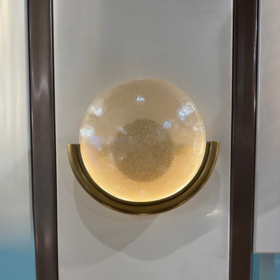Decorative wall piece with a round, textured center and gold frame on a white background
