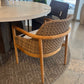 Round dining table with wicker chairs in a modern indoor setting