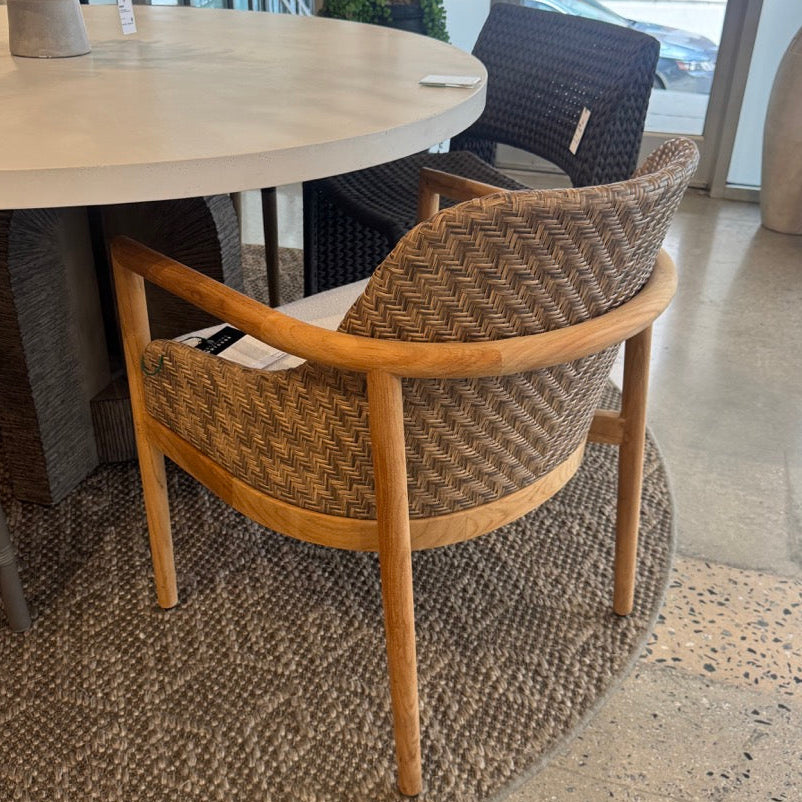 Round dining table with wicker chairs in a modern indoor setting