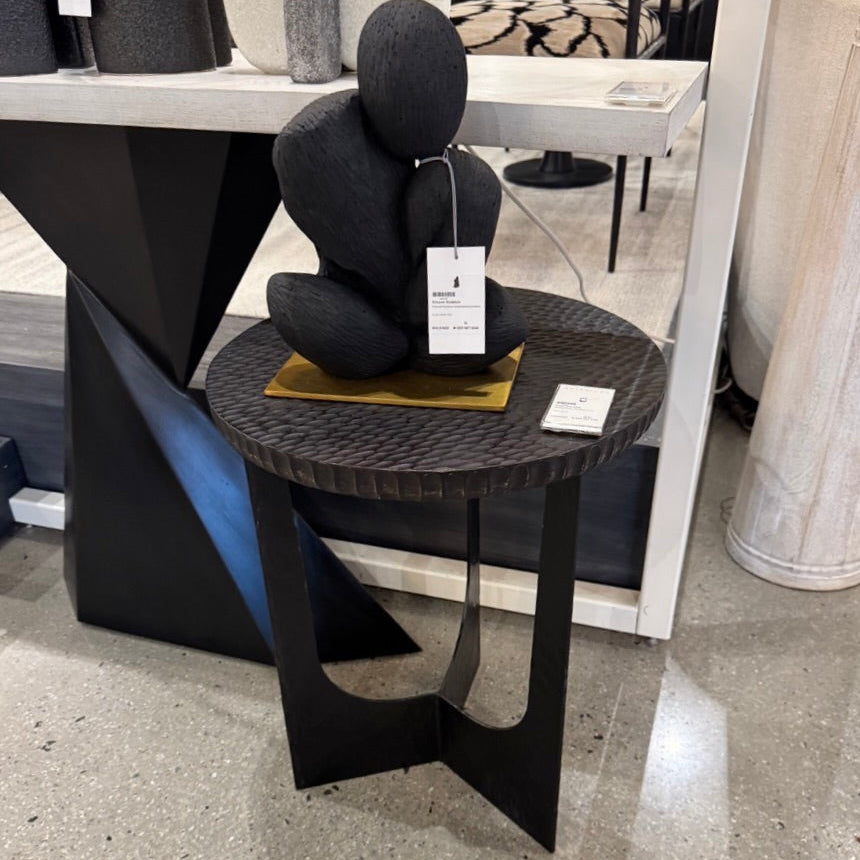 Black modern side table with a decorative item on top in an indoor setting