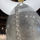 Close-up of a decorative lamp with a textured design on a blurred indoor background