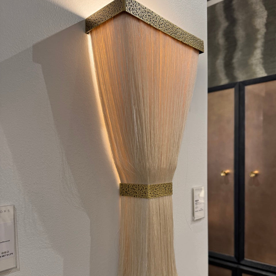 Wall-mounted light fixture with decorative elements on a white wall.