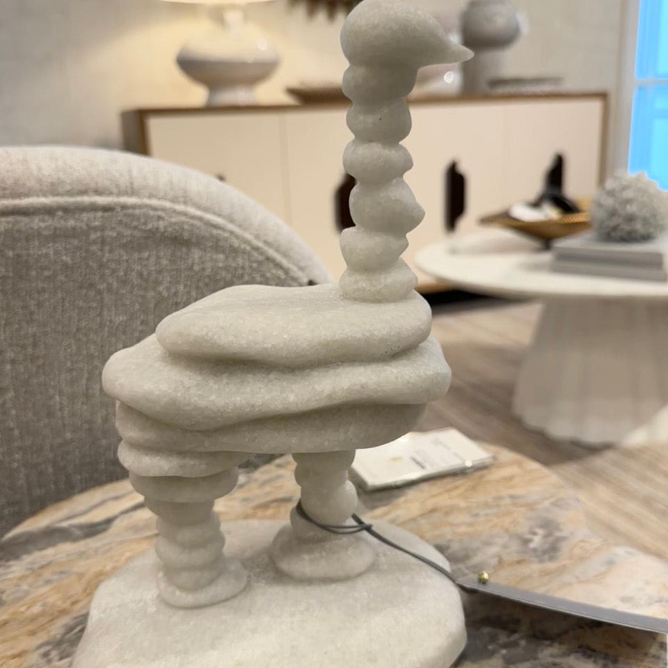 Decorative white sculpture on a wooden surface with a blurred background