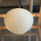 Round white ceiling light fixture on a textured wall background