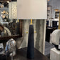 Table lamp with a white shade and black base in a store setting