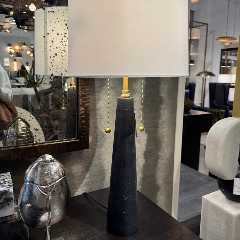 Table lamp with a white shade and black base in a store setting