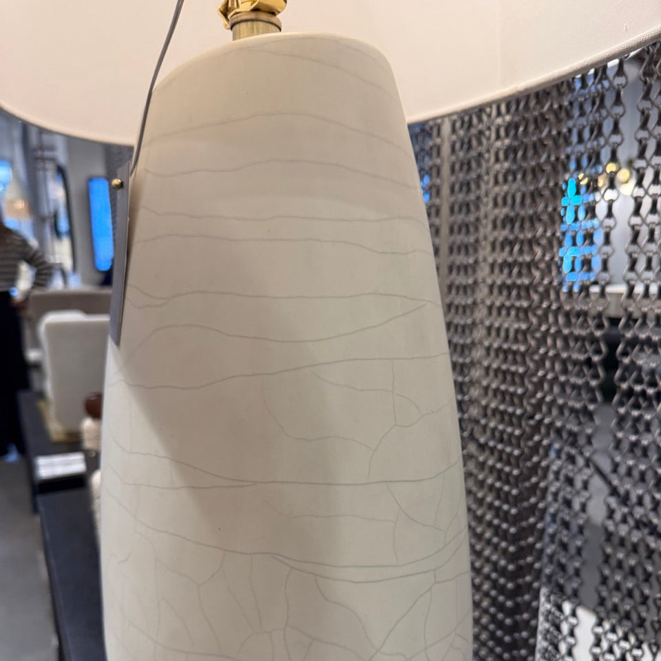 White ceramic vase with textured surface on a dark surface