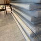 Stack of gray mattresses on a tiled floor