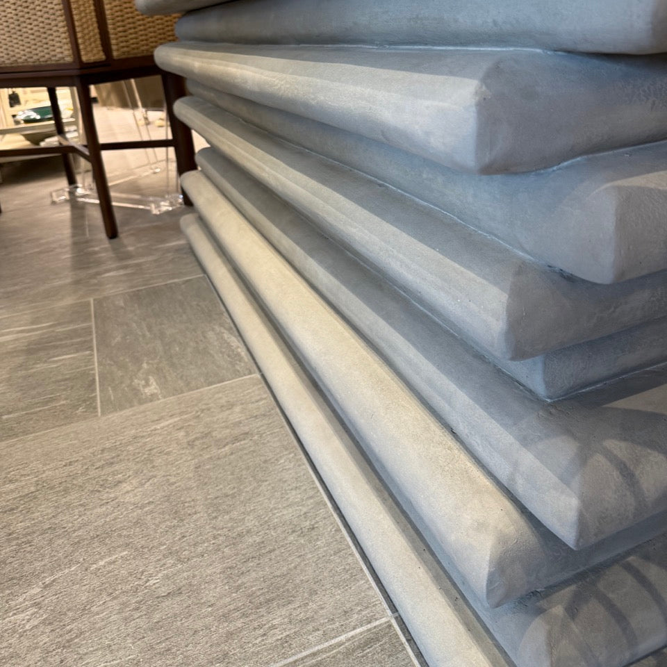 Stack of gray mattresses on a tiled floor