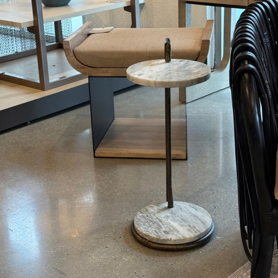 Small round marble table with a black base in an indoor setting
