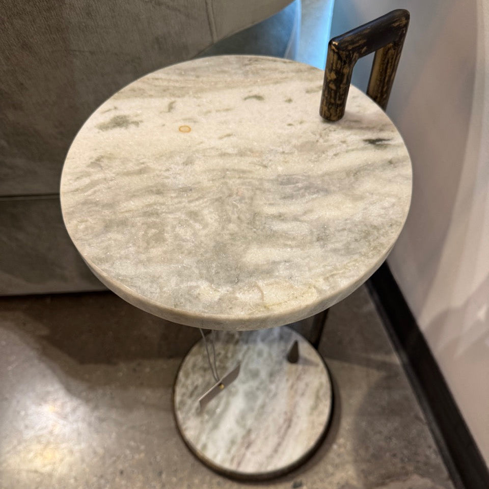 Round marble table with a textured surface on a concrete floor.