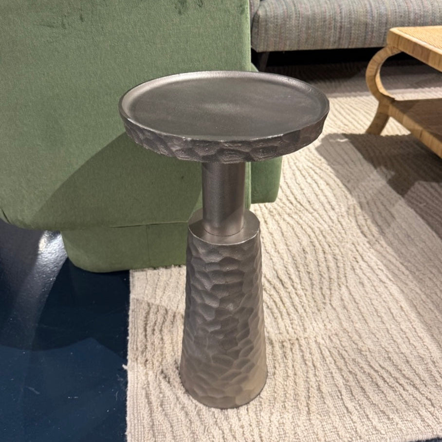 Decorative metal table with textured base in a living room setting