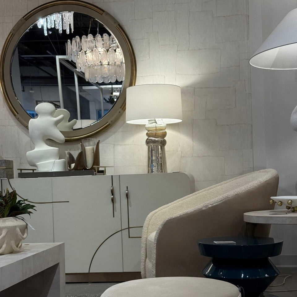 Modern interior design with round mirror, lamp, and furniture.