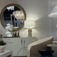 Modern interior design with round mirror, lamp, and furniture.