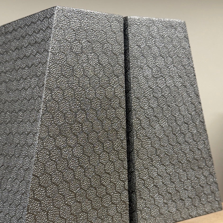 Two textured gray boxes on a beige surface