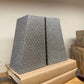 Two gray textured bookends on a cardboard box with a wooden surface and light-colored wall in the background.