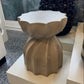 Decorative stone stool on a white surface with a textured background