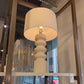 White floor lamp with a textured base in a store setting