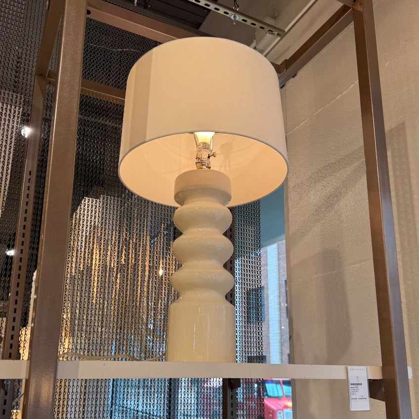 White floor lamp with a textured base in a store setting