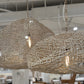 Woven pendant lights hanging in a room with furniture and decor.