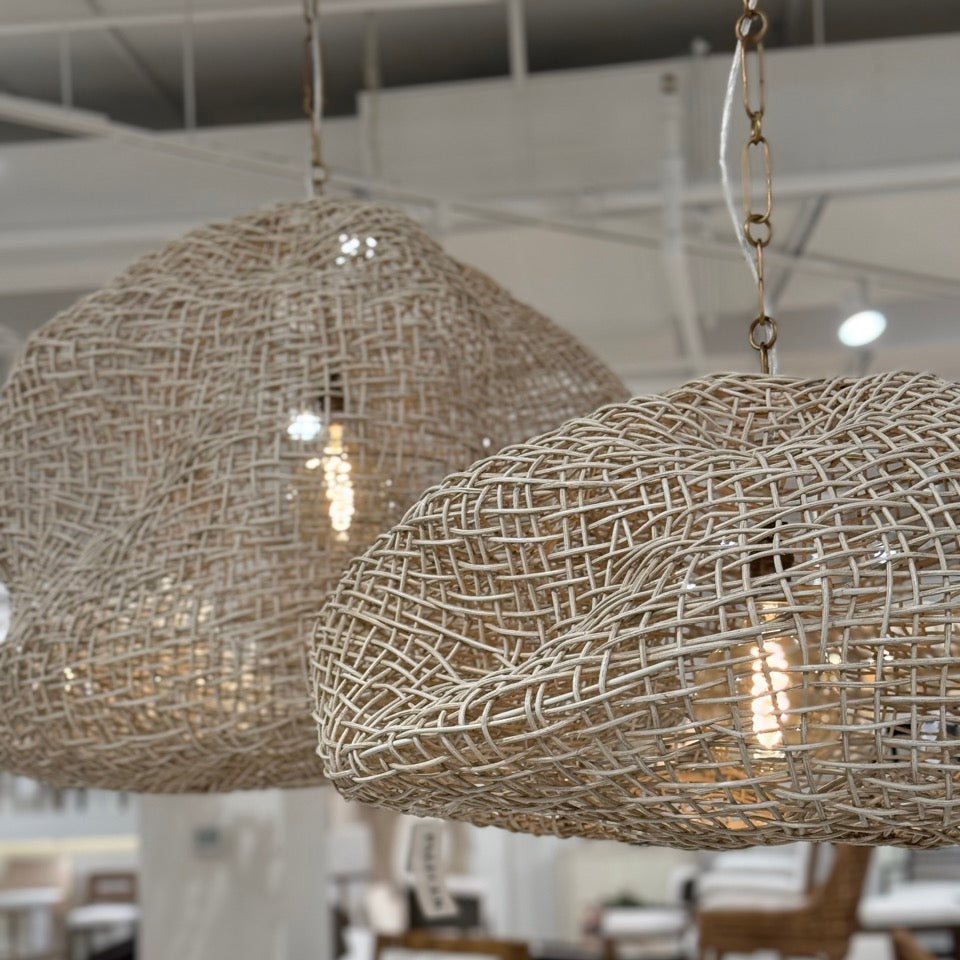 Woven pendant lights hanging in a room with furniture and decor.
